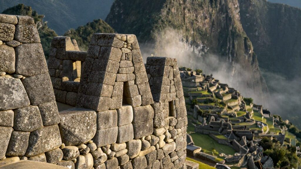 Bloques de granito perfectamente ensamblados de Machu Picchu bajo la luz del amanecer andino.