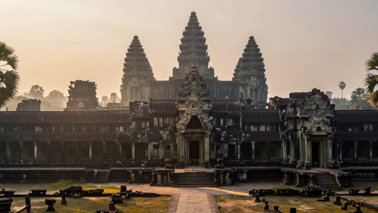 Templos de piedra de Angkor Wat emergiendo entre la bruma de la selva al amanecer.